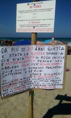 Cartello di protesta in spiaggia